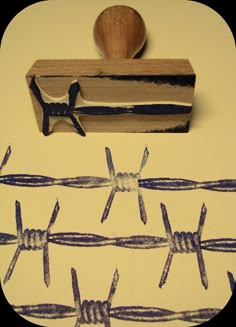 a rubber stamp with barbed wire on it and a piece of wood next to it