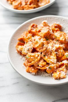 two white bowls filled with pasta and sauce