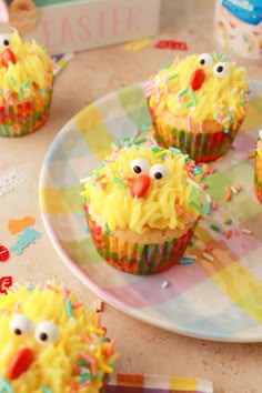 cupcakes decorated with yellow frosting and sprinkles on a plate