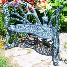 a metal bench sitting in the middle of a garden