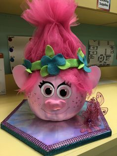 a close up of a pink troll head on a desk