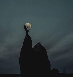 a person reaching up into the sky at night