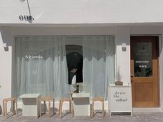 the outside of a coffee shop with tables and chairs