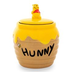 a yellow winnie the pooh cookie jar with a honey on it's lid