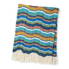 a multicolored knitted blanket with fringes