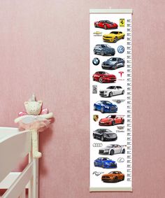 a growth chart with cars on it in a child's room next to a teddy bear