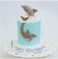 a blue and white cake with two dolphins on it