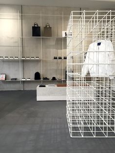 a room filled with lots of shelves and white clothing hanging from it's walls