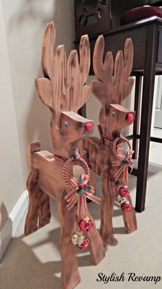 two wooden reindeers with bells attached to them