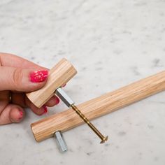 a person holding a wooden object with nails on it