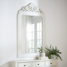 a white dresser and mirror in a room