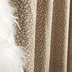 the curtains are lined up with white feathers