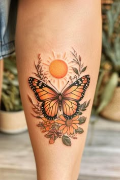 a woman's leg with a butterfly and flowers tattoo on the side of her thigh