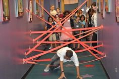 a group of people standing in front of a building with red tape on the floor