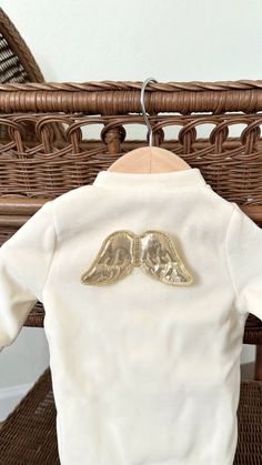 a white shirt with gold wings on it