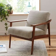 a chair sitting on top of a wooden floor in front of a potted plant