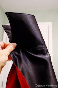 a person is holding up a black and red jacket