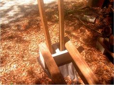 two wooden poles sticking out of the ground in front of a tree and grass area