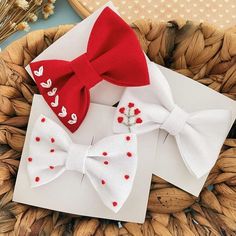 two red and white bow ties sitting on top of a card next to each other