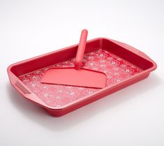 a pink tray with a spatula on it