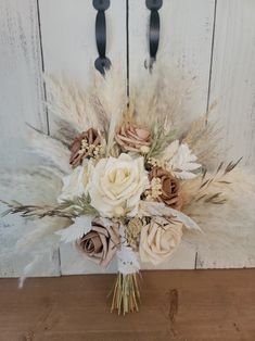 a bouquet of flowers sitting on top of a wooden table next to a white door