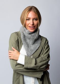 a woman with her arms crossed wearing a scarf