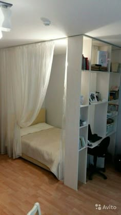 a bedroom with a bed, desk and book shelf in the corner next to a window