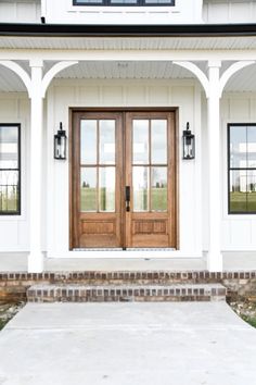 a white house with two double doors and brick steps