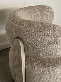 an upholstered chair sits in front of a wall