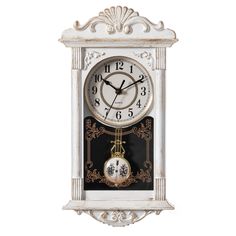 a white clock with black and gold designs on it