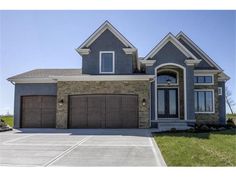 a large house with two garages in the front and one on the other side