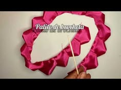 a person holding a stick in front of a heart shaped piece of paper with the words palati de brocheta on it