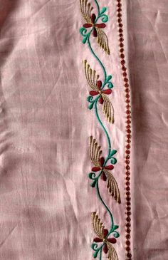 an embroidered pink shirt with green and red flowers on the front, along with beaded trim