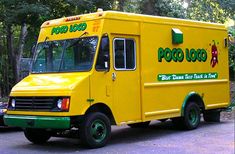 a yellow food truck is parked on the side of the road in front of some trees