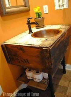 a bathroom sink made out of an old wooden box with two rolls of toilet paper on it