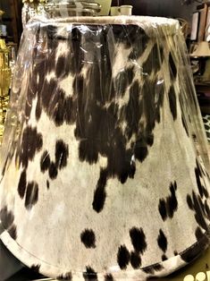 a cow print lamp shade sitting on top of a table