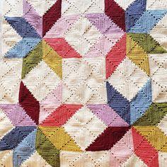 a multicolored crocheted quilt on display