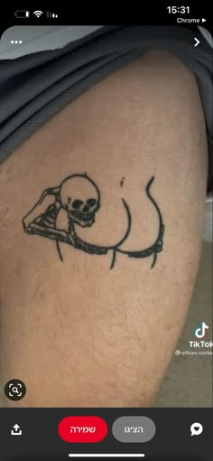 a person with a tattoo on their thigh that has a skull and knife in it