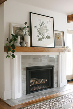 a fireplace with pictures on the mantle and potted plants next to it in a living room