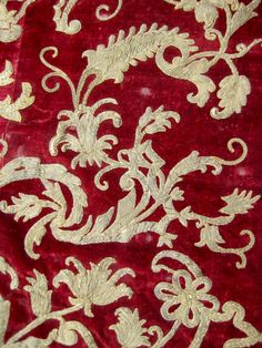 red and gold brocade with white flowers on it's side, close up