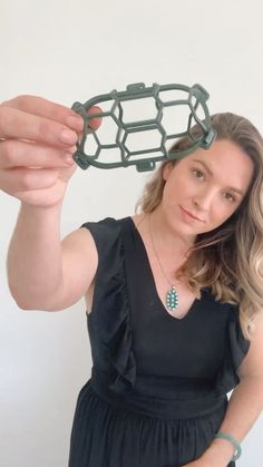 a woman holding up a piece of wire to her face