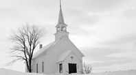 black and white photograph of a church in the snow