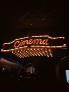 an old neon sign is lit up in the dark