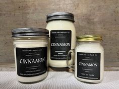 three jars with labels on them are sitting next to each other, one is filled with cinnamon