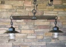 three lights hanging from the side of a stone wall