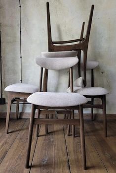 three wooden chairs sitting on top of a hard wood floor