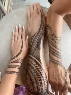 two people with tattoos on their arms and legs, one holding the other's hand