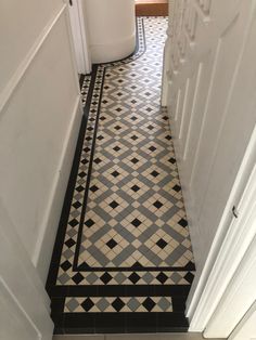 a hallway with black and white floor tiles