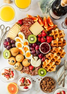 a table topped with lots of different types of food next to glasses of orange juice