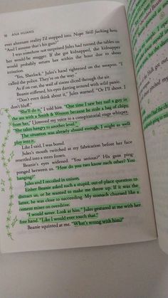 an open book with green writing on it